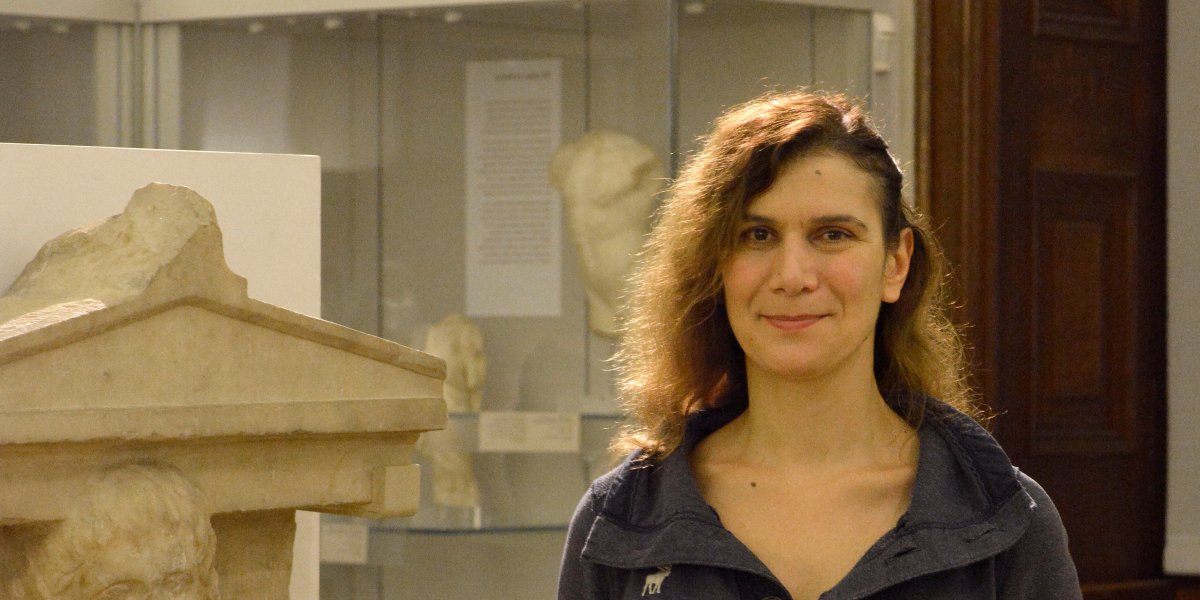 Anastasia Christophilopoulou in the Fitzwilliam Museum beside a statue.