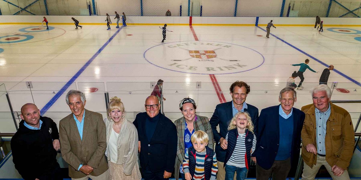 Group photo from the stands with skaters on the ice in the background