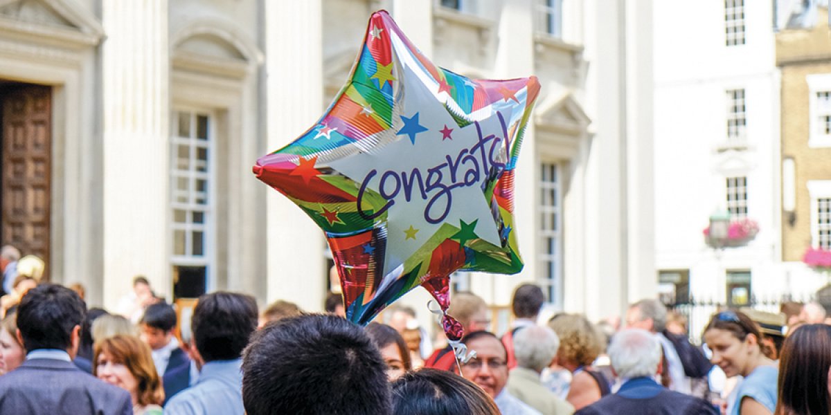 Congrats balloon amongst crowd on Senate House Lawn at graduation