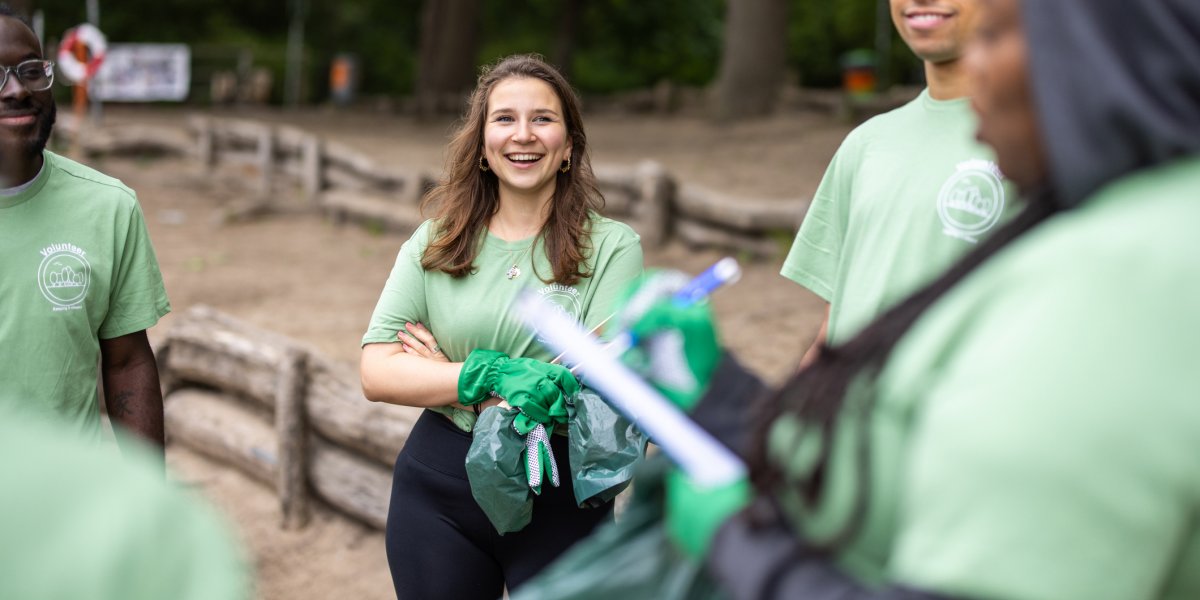 photograph depicting volunteers in a woodland setting talking and laughing
