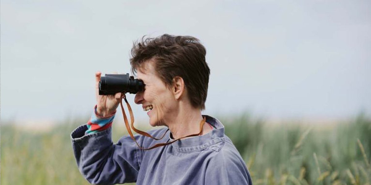 Professor Carol Brayne holding binoculars