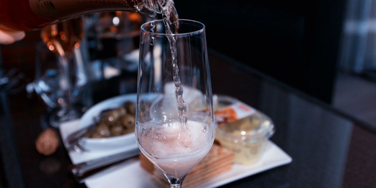 Sparkling wine being poured at a dinner table