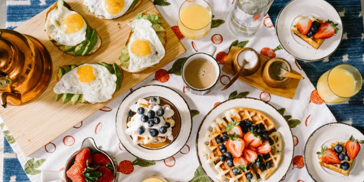 A breakfast spread of waffles, fried eggs, toast, coffee and orange juice