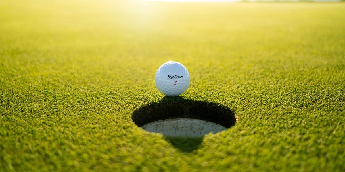 A golf ball on the edge of the hole