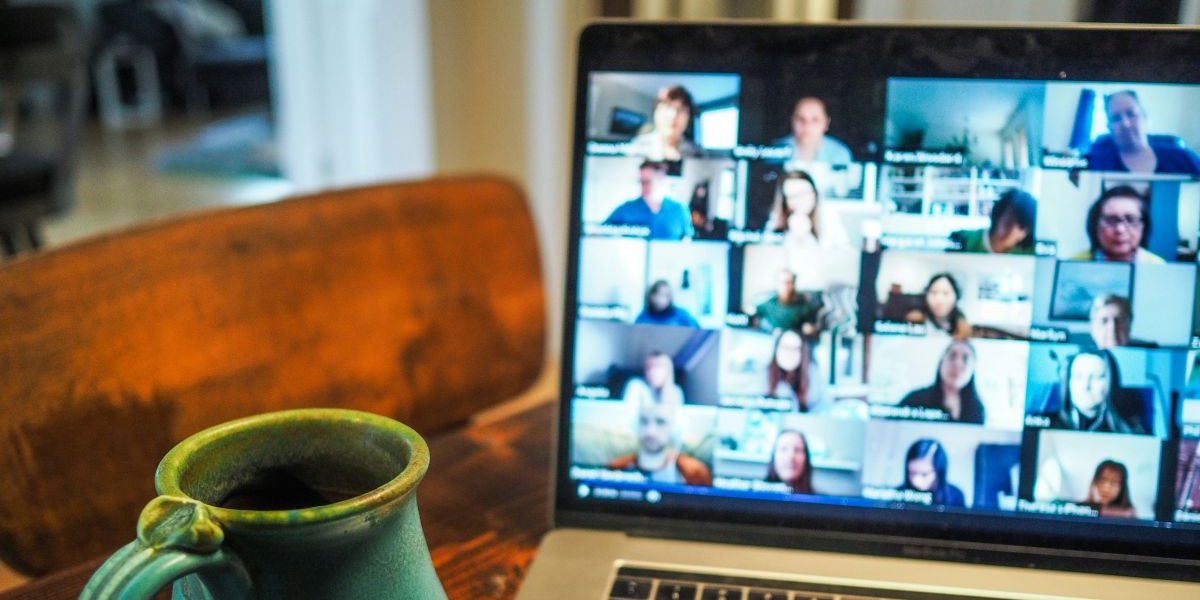 A laptop and cup of coffee sit on a desk