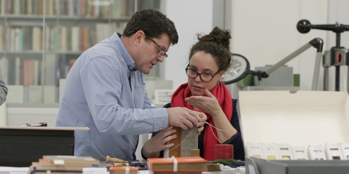 two people working on conservation of a book