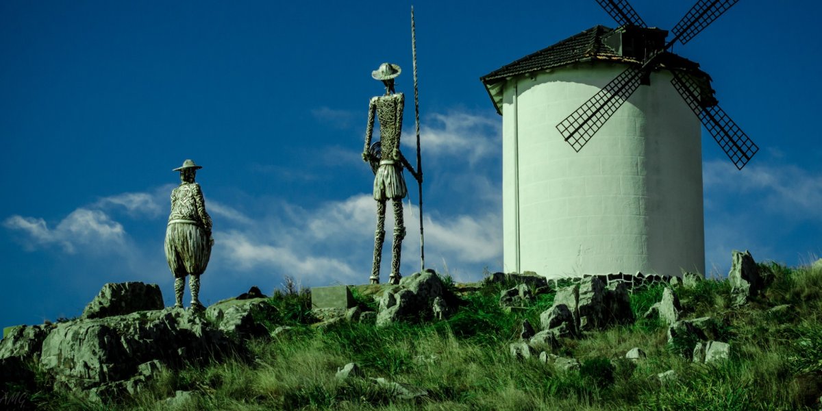 Picture of windmill and farmers looking out to a blue sky