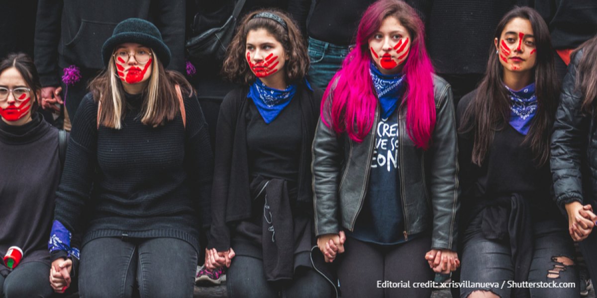 Line of women with a red hand print over their mouths