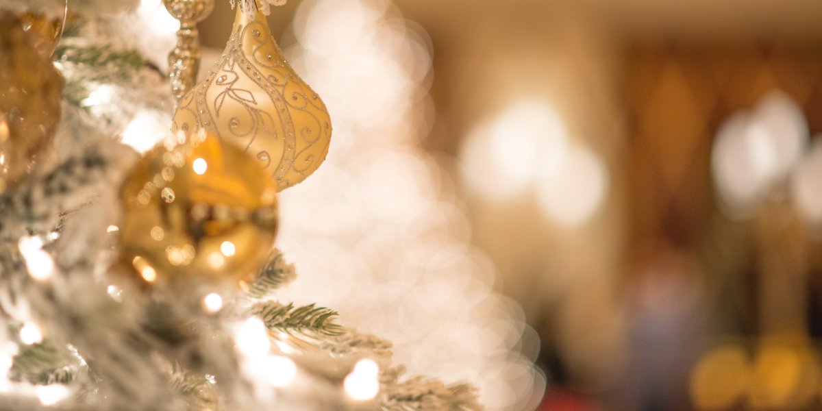 Gold ornament hanging from a Christmas tree