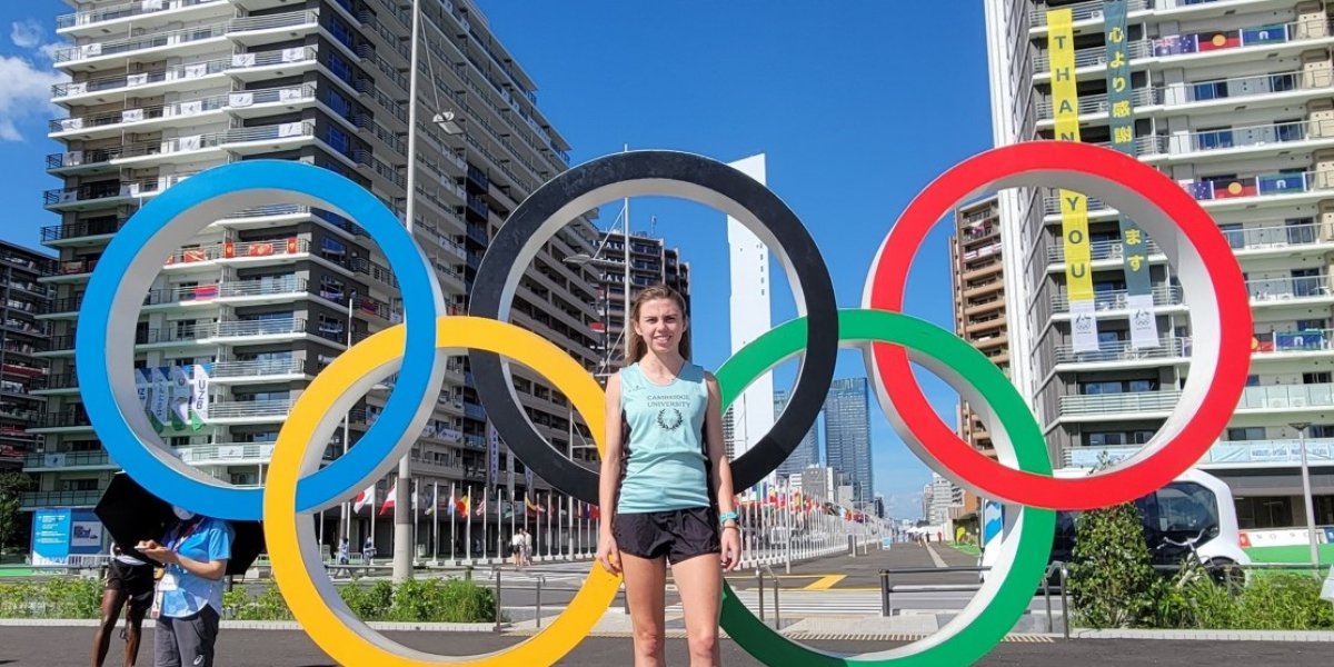 Student athlete in front of the Olympic rings