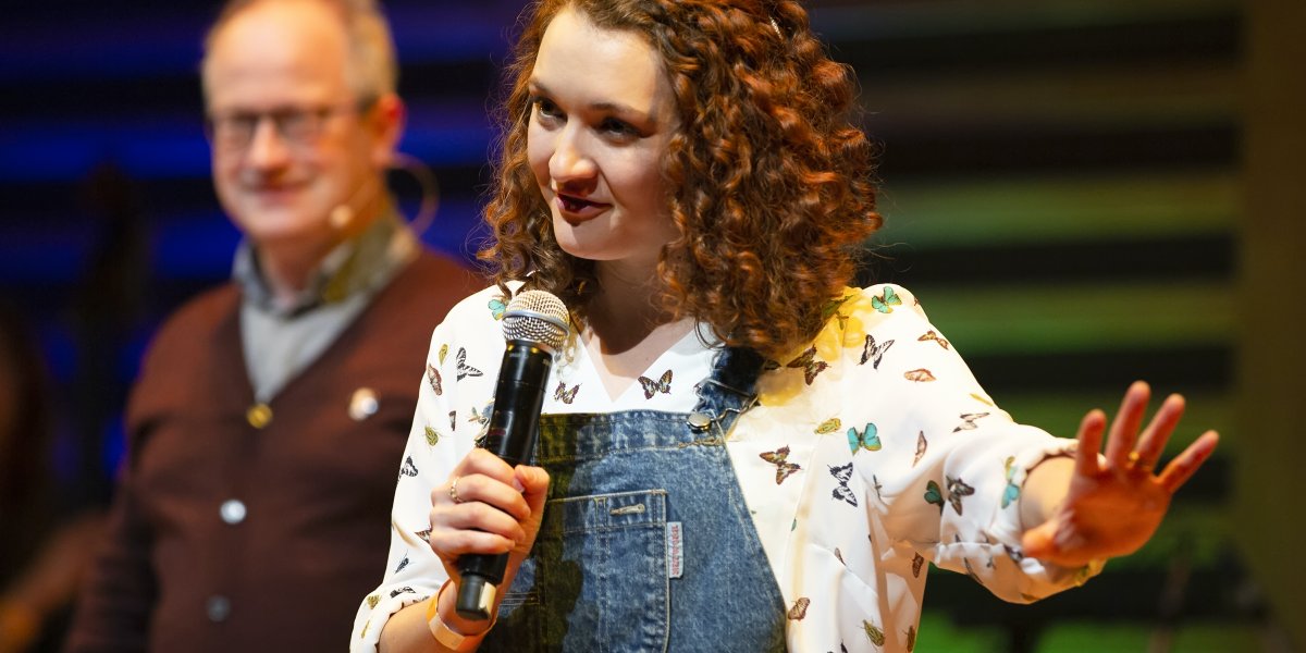 Image of Ginny Smith on stage talking 
