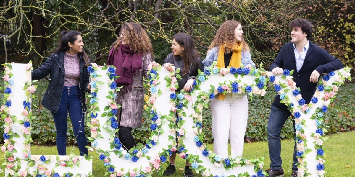 'Lucy' spelt out in flowers with members of the Committee