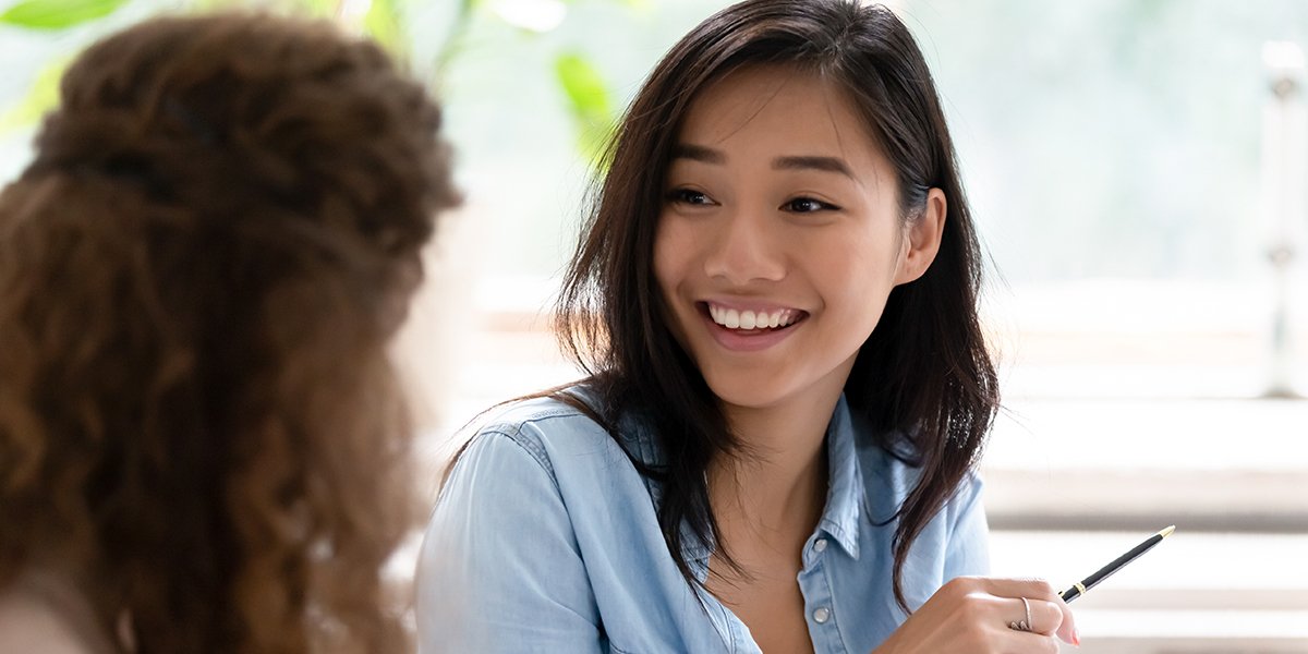 young woman speaking to another woman