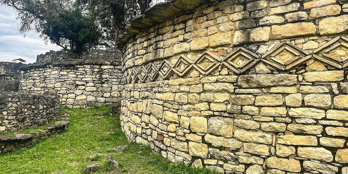 Curved stone walls with geometric carvings at the Kuelap archaeological site, Peru