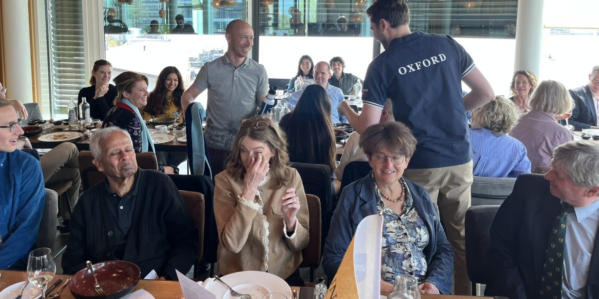 photograph of a group of people watching the boat race at an alumni event