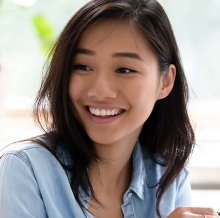 A woman smiles in a sunny place