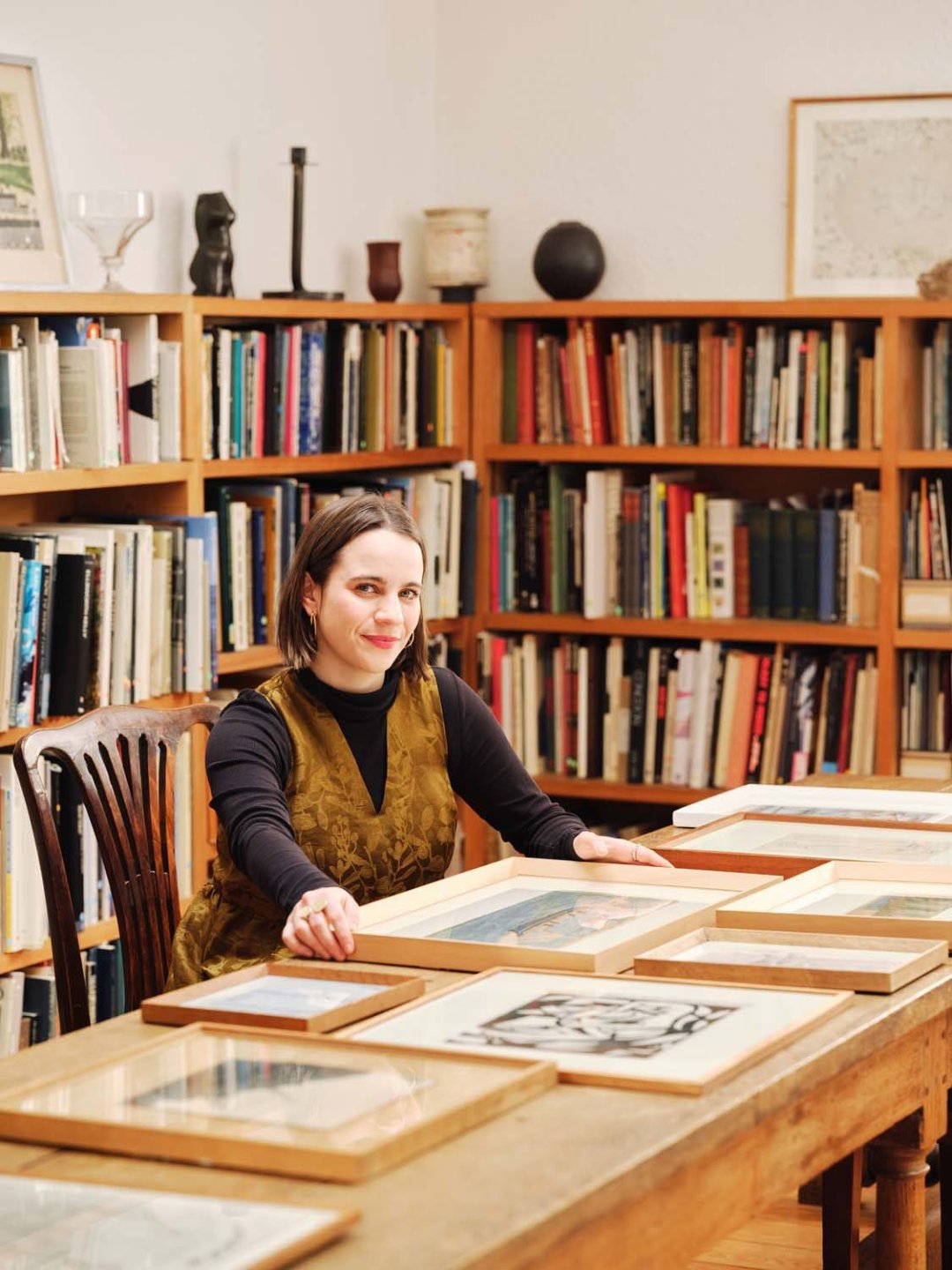 Naomi Polonsky sitting by paintings