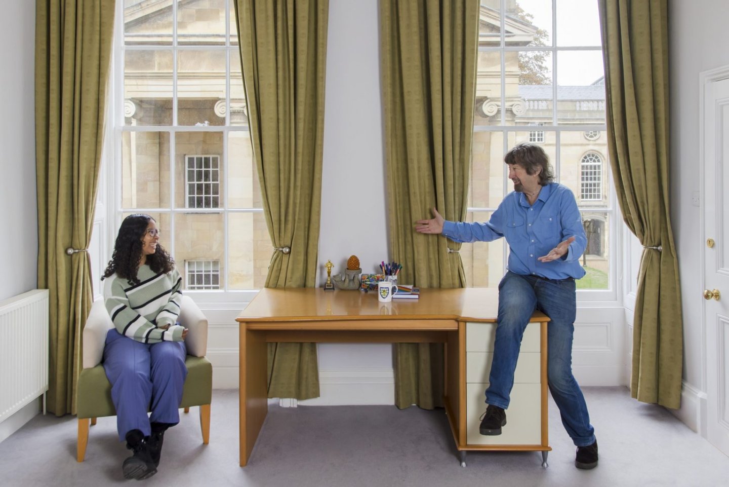 Alumnus and student in room